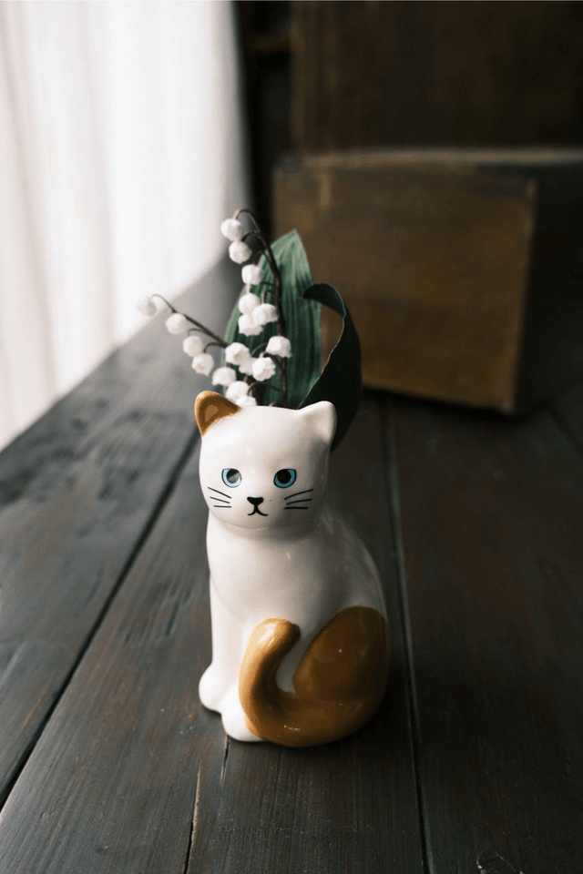 Lily of the valley in cat vase