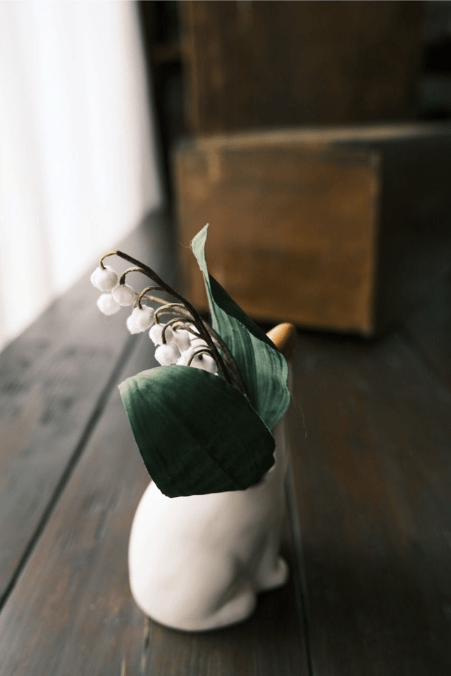 Lily of the valley in cat vase